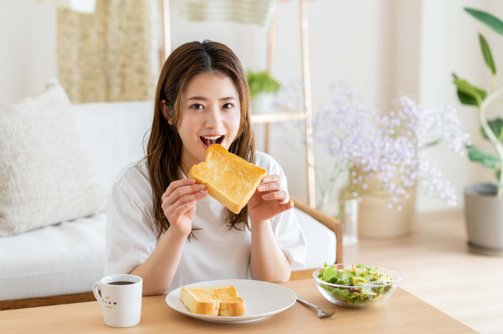 虫歯を治療して笑顔で食事を楽しむ女性