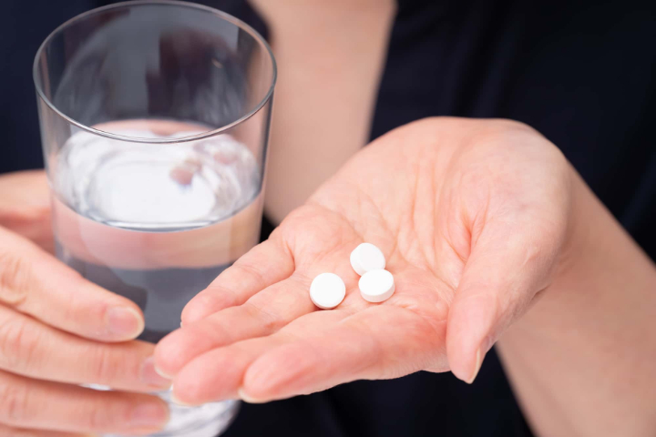 虫歯が痛くて眠れない時に鎮痛剤を飲むイメージ