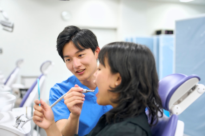 矯正治療前に虫歯が見つかった説明をする歯科医師