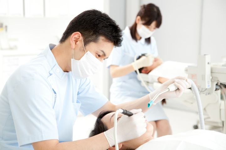 矯正治療中に虫歯が見つかって治療する女性