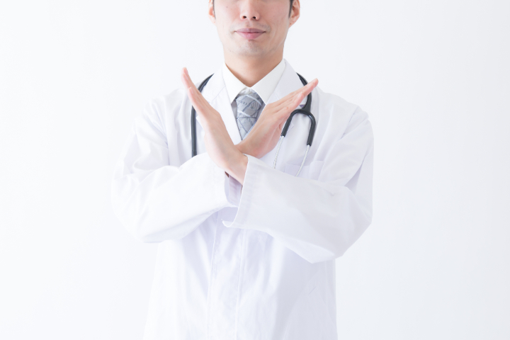 歯周病の外科治療を受けられない人について説明する歯科医師
