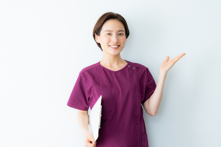 アタッチメントの種類を紹介する歯科医師の女性